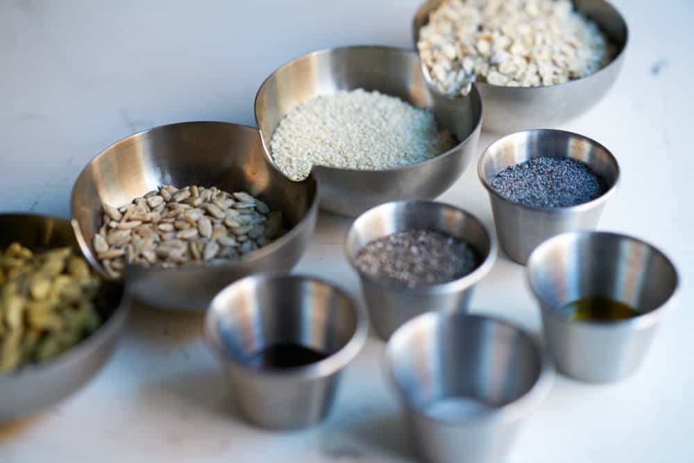 Small metal bowls filled with seeds, oil and seasonings. 
