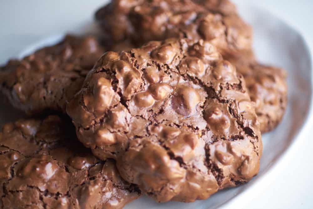 Gluten-free double chocolate hazelnut cookies on a white ceramic plate.