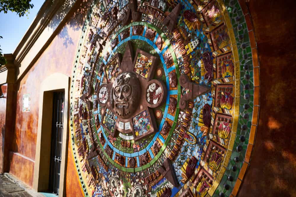 A colorful Aztec calendar in relief on the side of a building in Todos Santos, Mexico, by artist Donna Billick. 