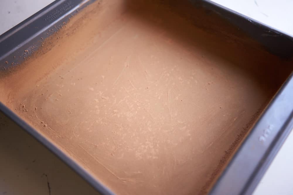 A square, 9 inch by 9 inch pan that has been greased with butter and coated with cocoa powder.