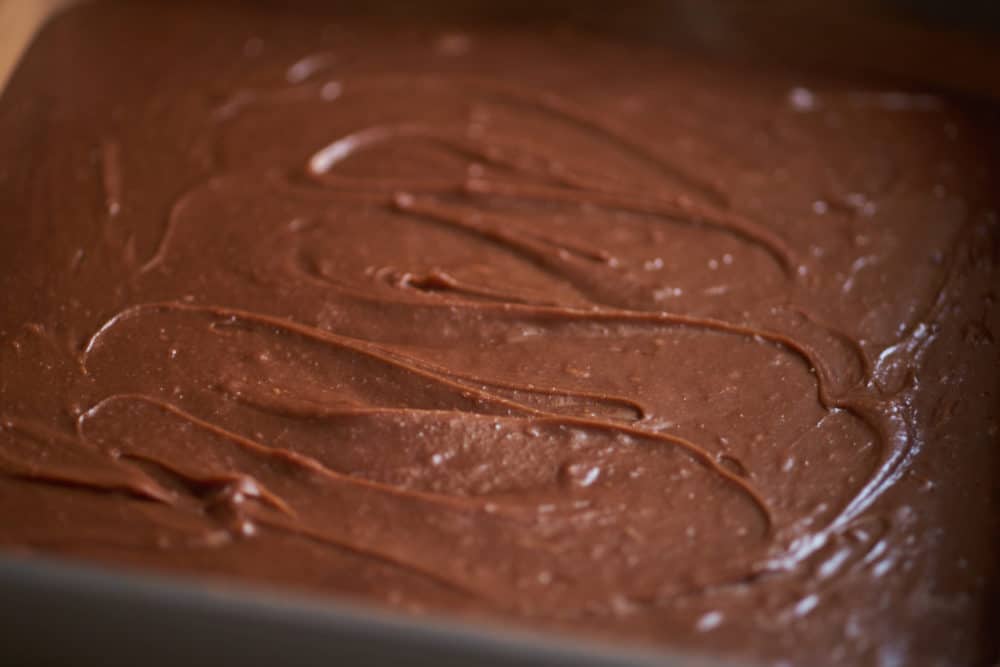 A square 9 inch by 9 inch baking pan full of brownie batter.