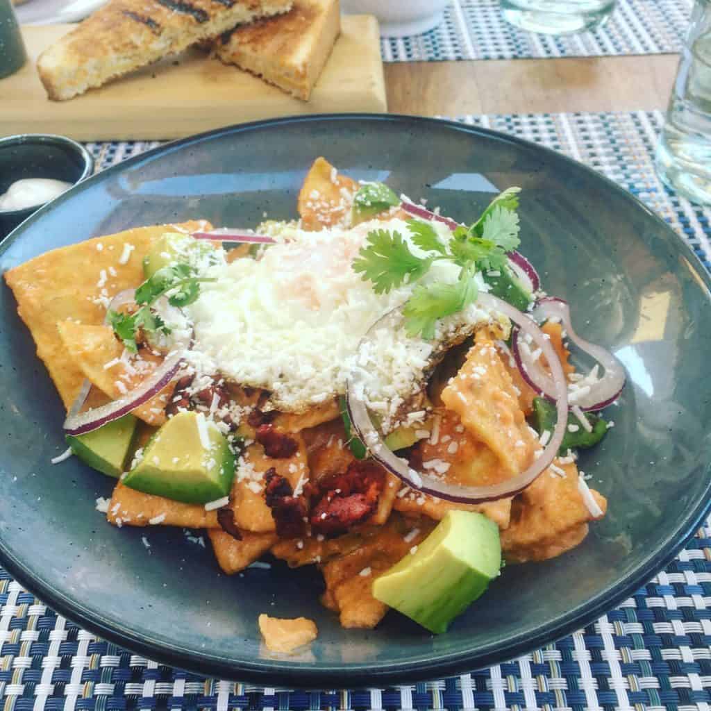 Chilaquiles with fried egg and avocado in a blue bowl at Rancho Pescadero, Baja California Sur.