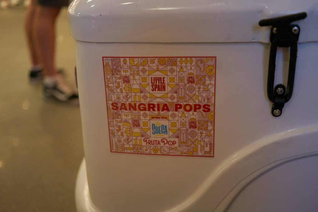 A popsicle cart that says Sangria Pops on the side of it. 