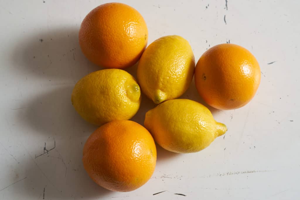 Fresh oranges and lemons arranged in a triangle pattern.