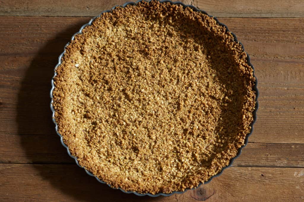 Baked gluten free tart crust cooling on a table.