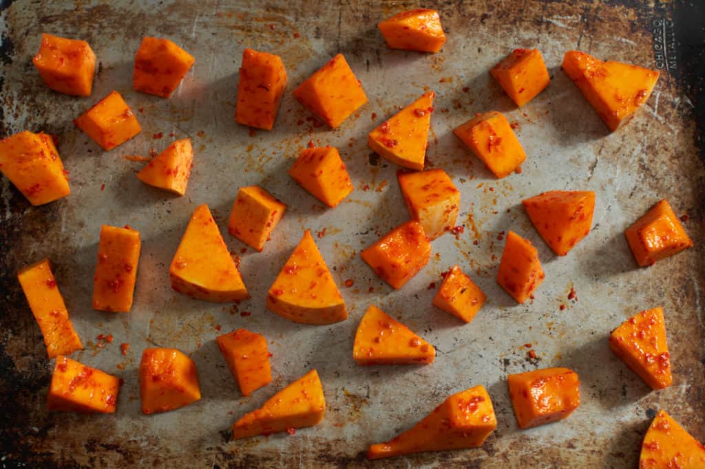 Butternut squash coated in harissa ready to be baked.