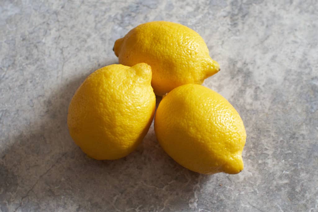 Three lemons on a gray surface