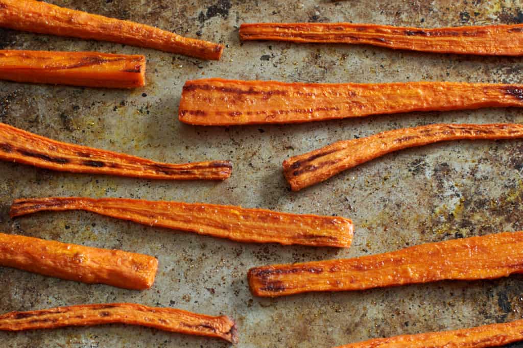 Oven roasted carrots on a baking sheet.