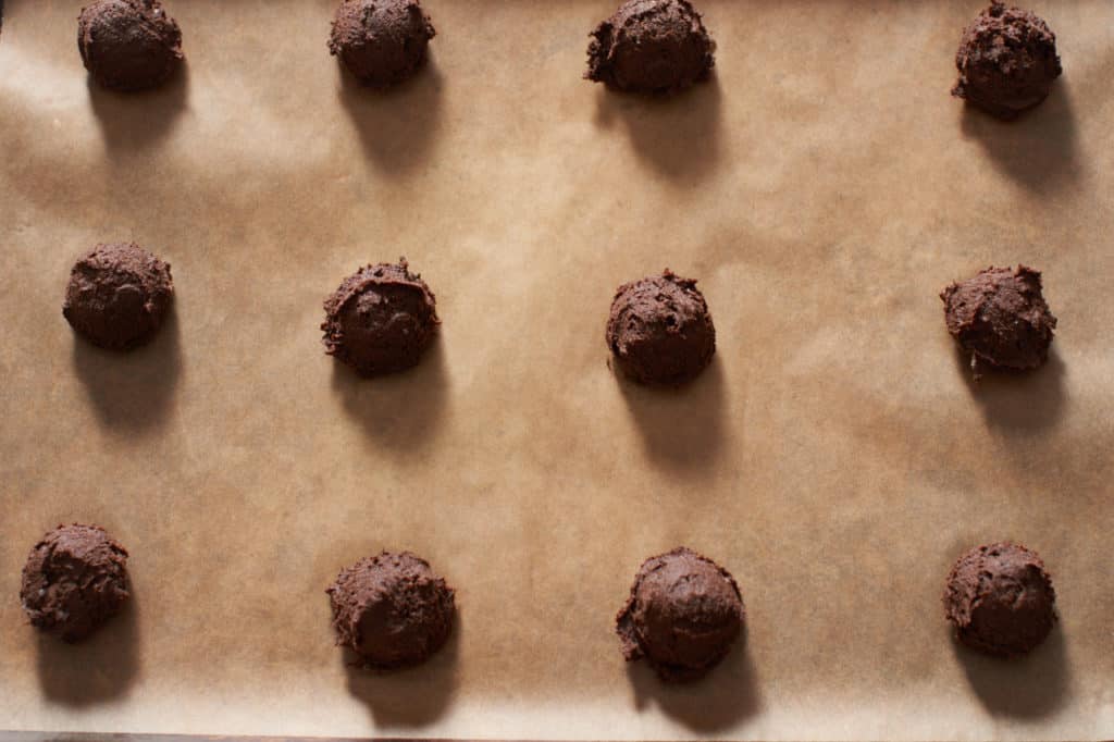 Gluten free chocolate buckwheat cookies on parchment paper ready to go into the oven.