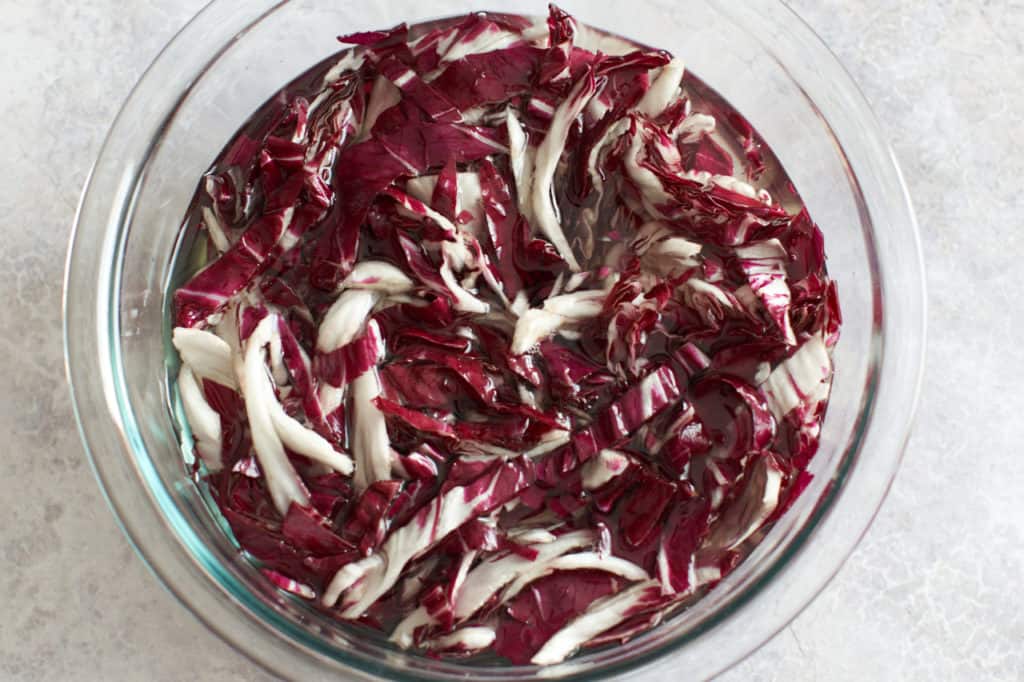 Sliced radicchio soaking in a bowl of water.