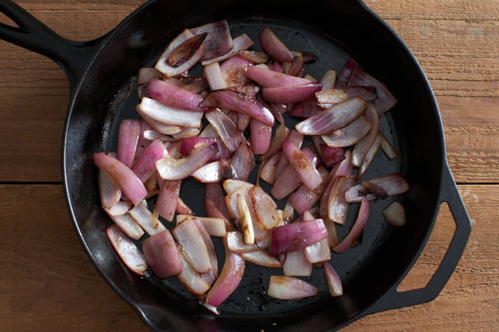 Caramelized red onions in a cast iron skillet.