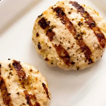 Two grilled turkey burgers on a white plate.
