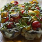 Open-faced eggplant caprese sandwich topped fresh tomatoes, basil and balsamic reduction.