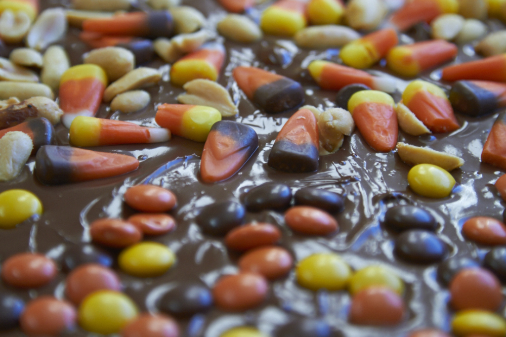 Candy corn and nuts on top of melted chocolate.