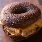 A pumpernickel bagel with turkey and melted cheese.