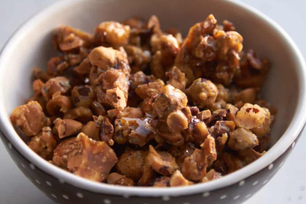 Candied hazelnuts in a bowl that is brown with white polka dots.