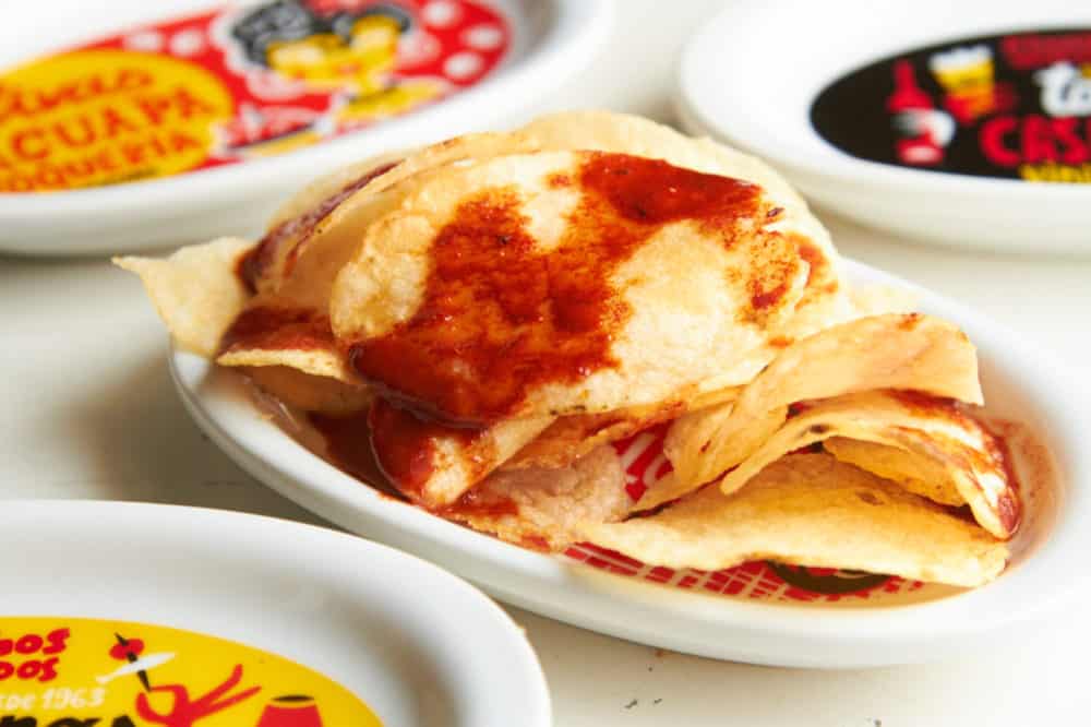 Paprika chips surrounded by colorful plates with writing in Spanish.