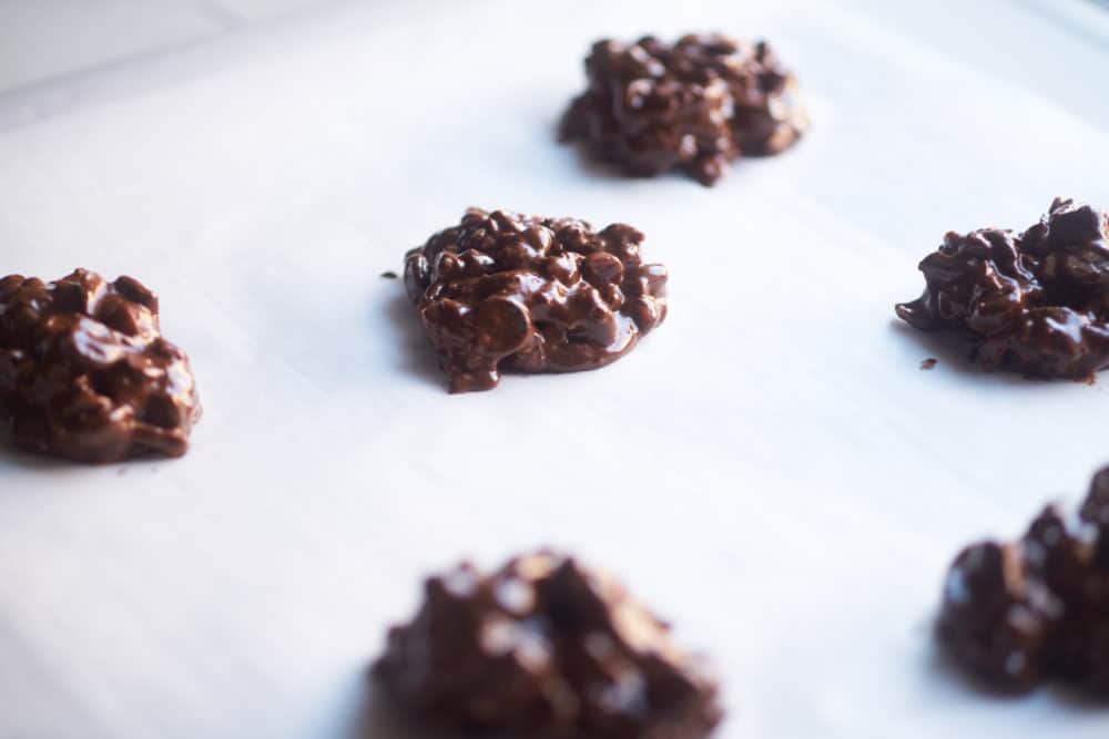 Flourless chocolate cookies on a parchment sheet ready to be baked.