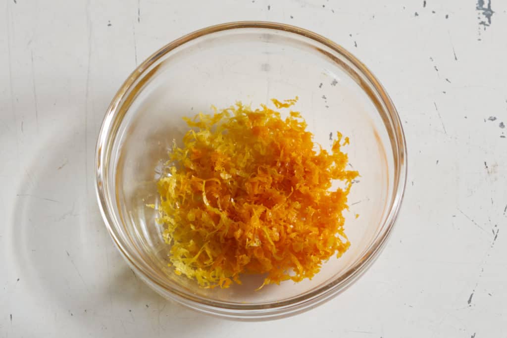 A small glass bowl filled with lemon and orange zest.