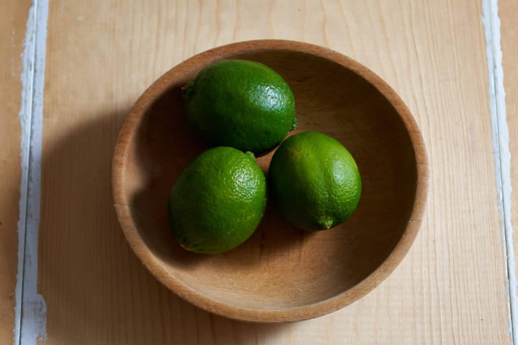 Three limes in a wooden bowl.