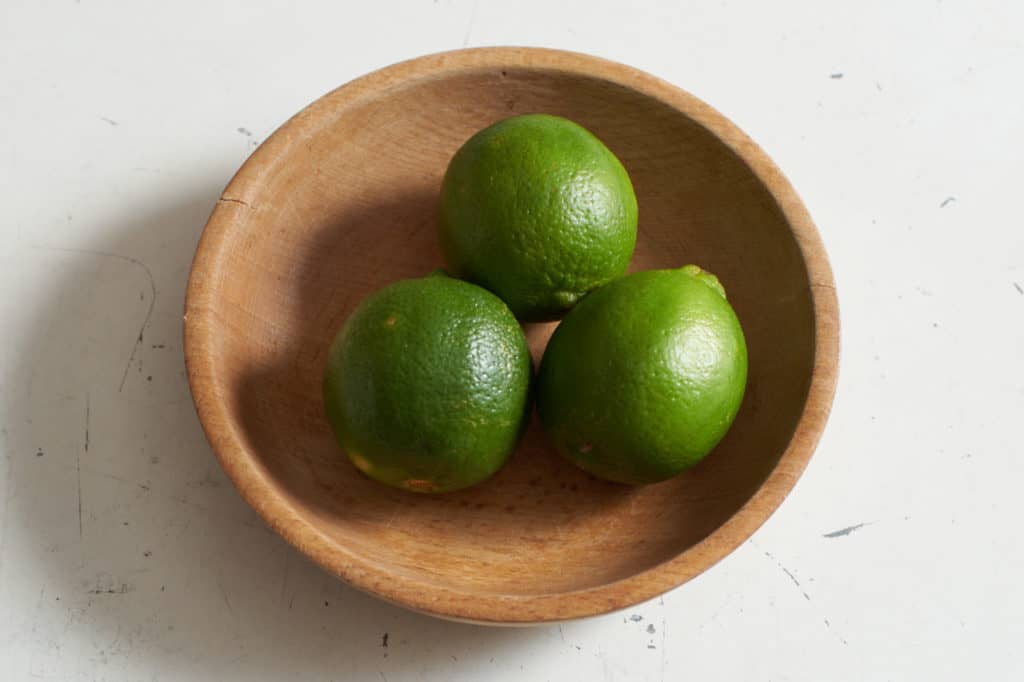 Three limes in a wooden bowl.