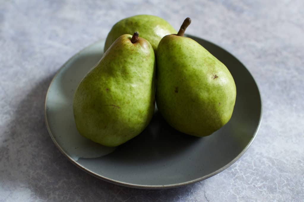 Three pears on a gray plate.