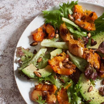 A plate of harissa roasted butternut squash salad with avocado.