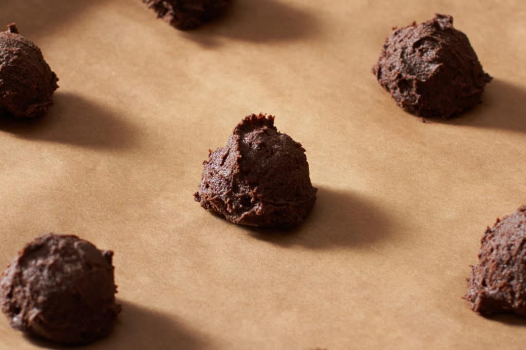 Gluten free chocolate buckwheat cookies on parchment paper ready to go into the oven.