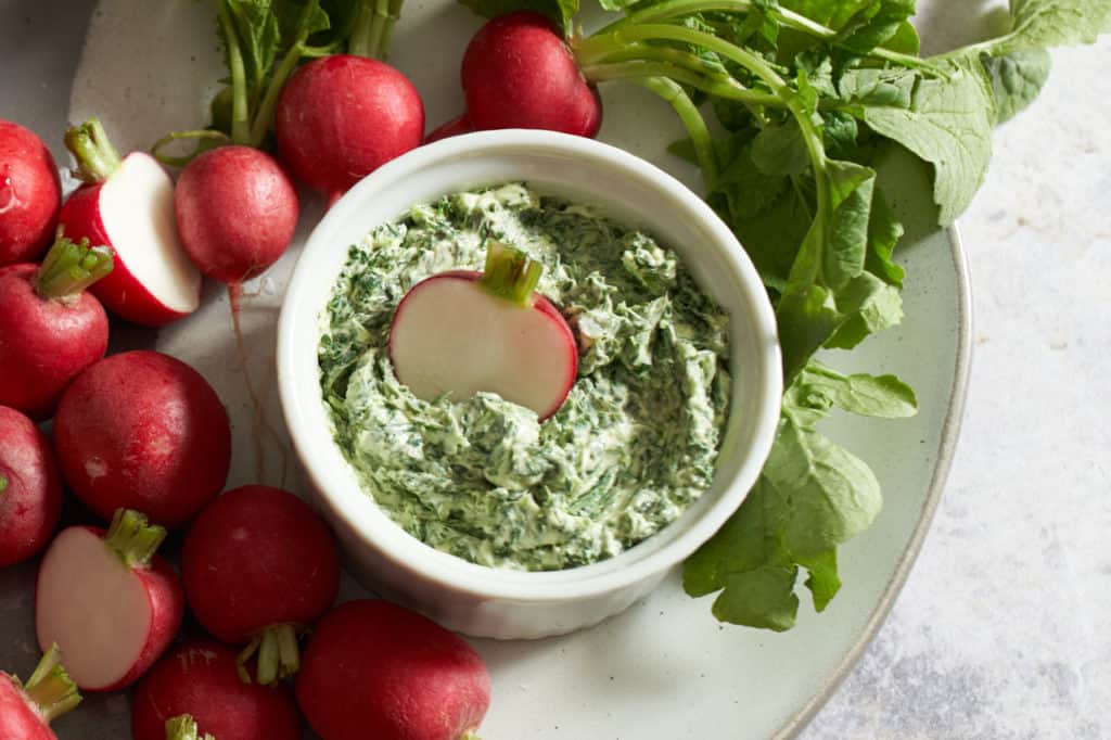 radishes with radish leaf butter on a plate