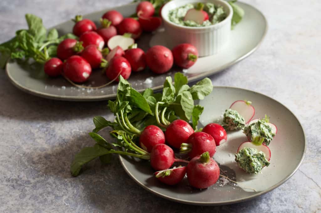 radishes with radish leaf butter on a plate