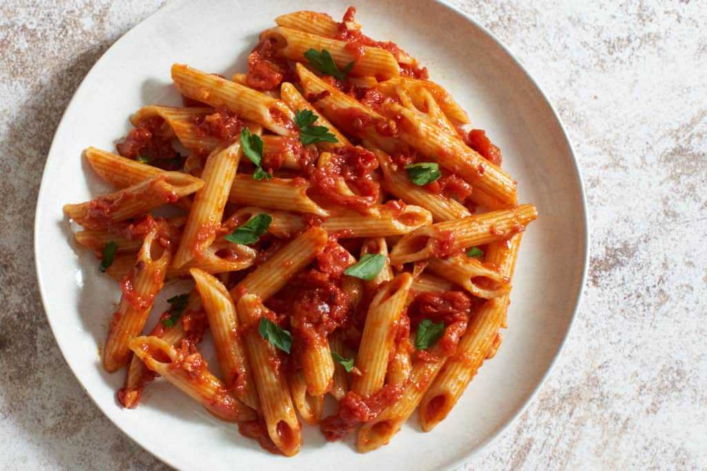 Penne all'arrabbiata on a white plate.