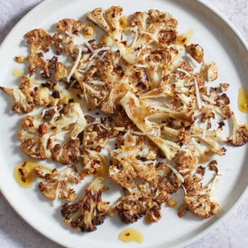 Crispy roasted cauliflower with parmesan on a white plate