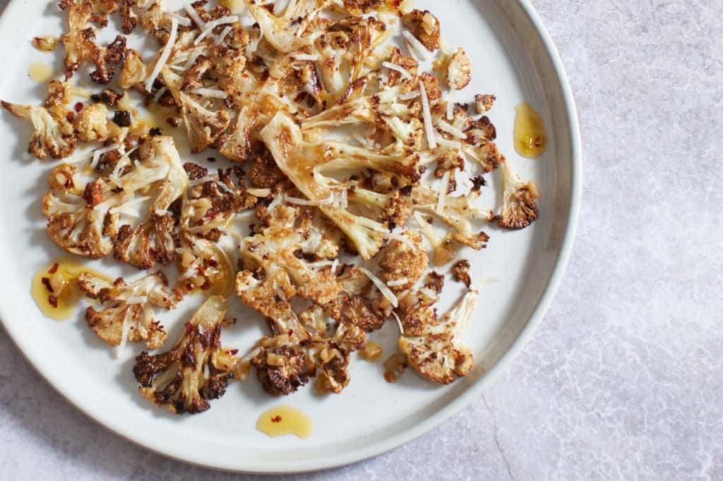 Crispy roasted cauliflower with parmesan on a white plate