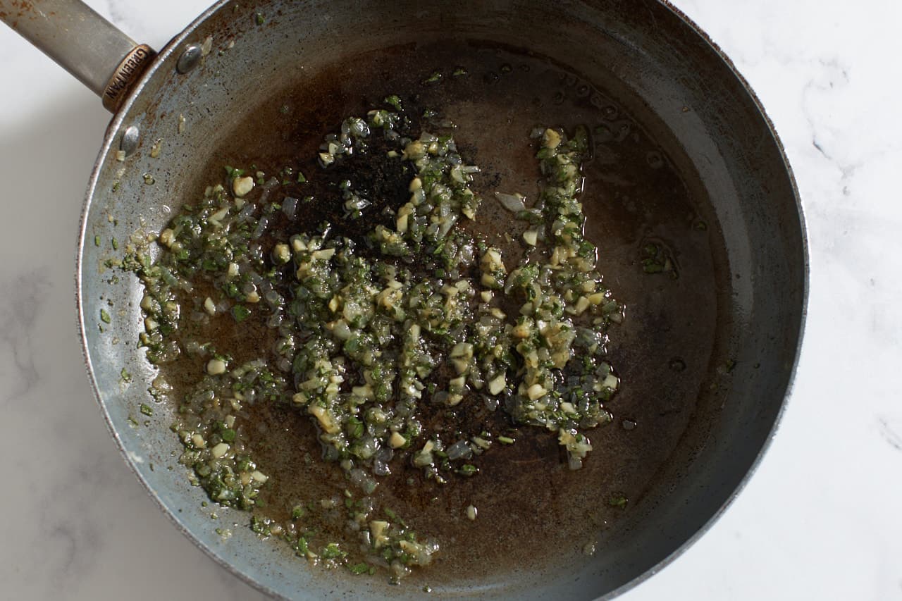 Sauteéd shallots, garlic, and sage in a skillet.