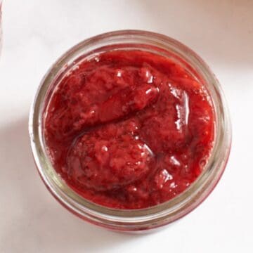 Topdown view of a small jar of strawberry compote.