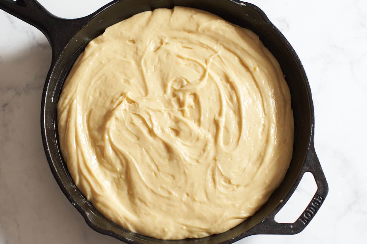 Cake batter in a cast iron skillet.