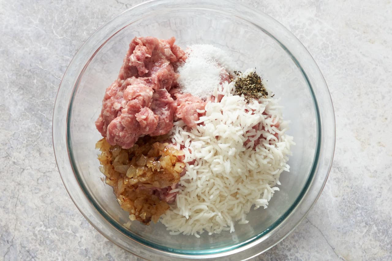 A bowl of ground pork, par-cooked rice, caramelized onions, salt, and pepper.