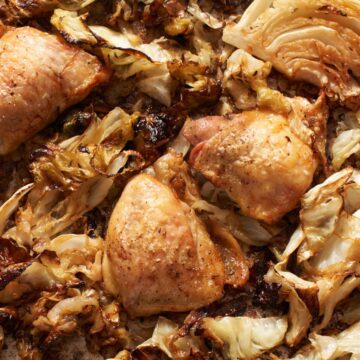 Chicken and cabbage with onions roasted on a sheet pan.