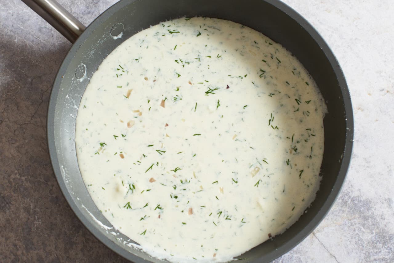 Finished dill cream sauce in a skillet.