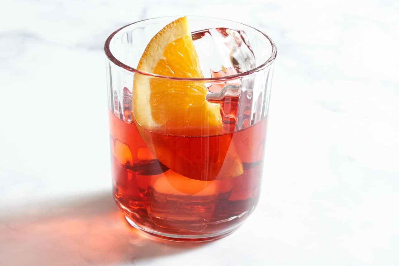 A Milano Torino cocktail garnished with an orange slice.