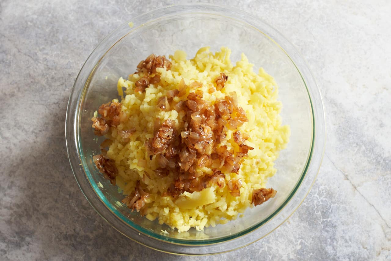 Caramelized onions in a bowl of mashed potatoes.