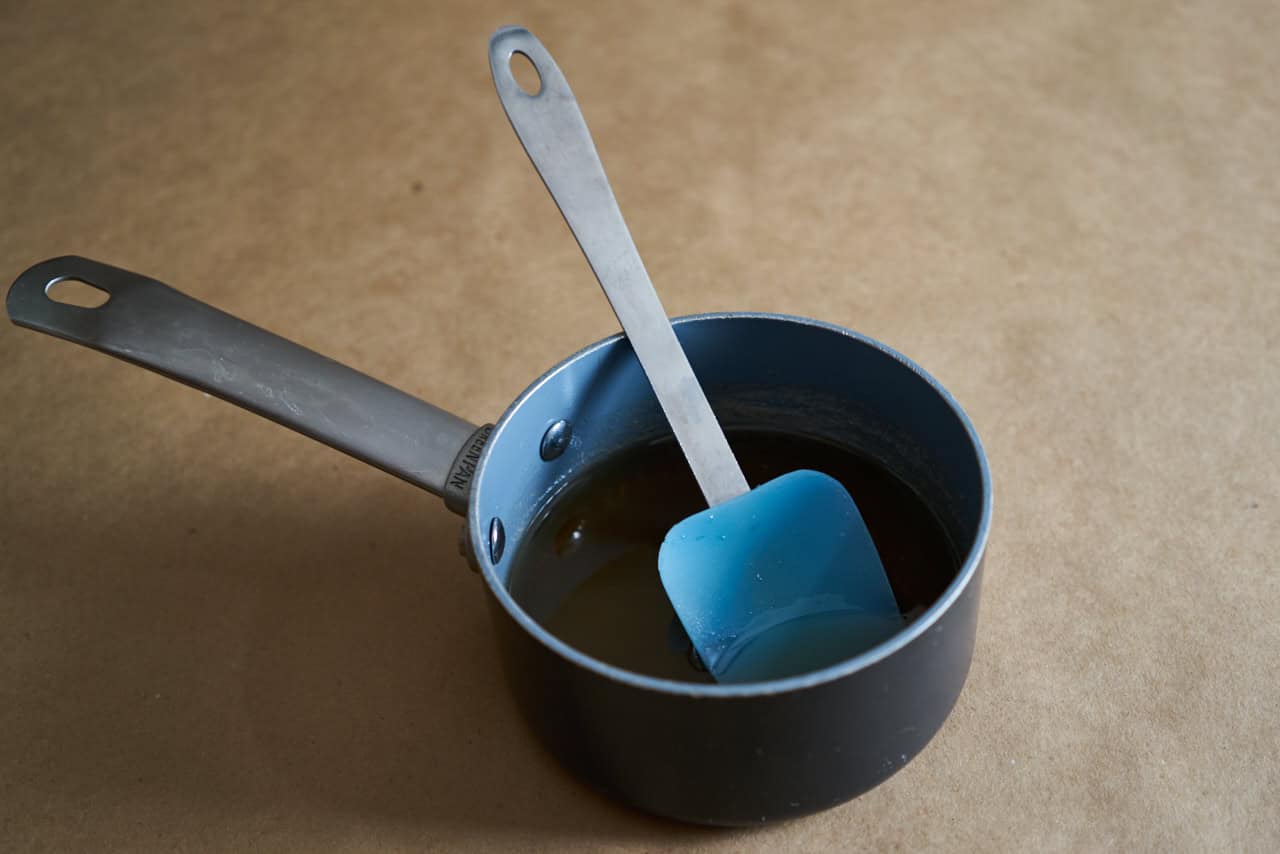 A spatula in a small sauce pan of simple syrup.