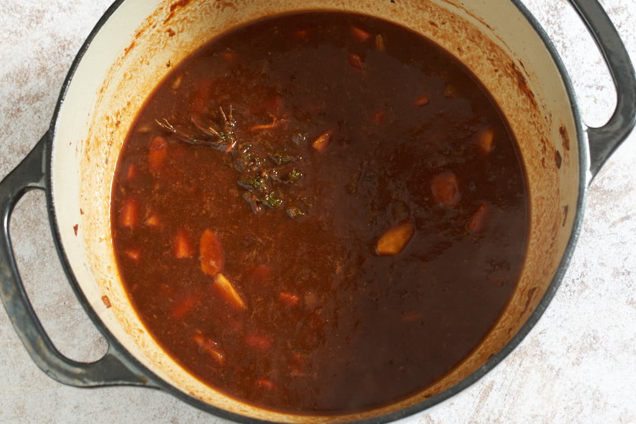 Guinness beer has been added to a mixture of chopped vegetables with tomato paste and herbs, it is a thick liquid that forms the base of a stew.