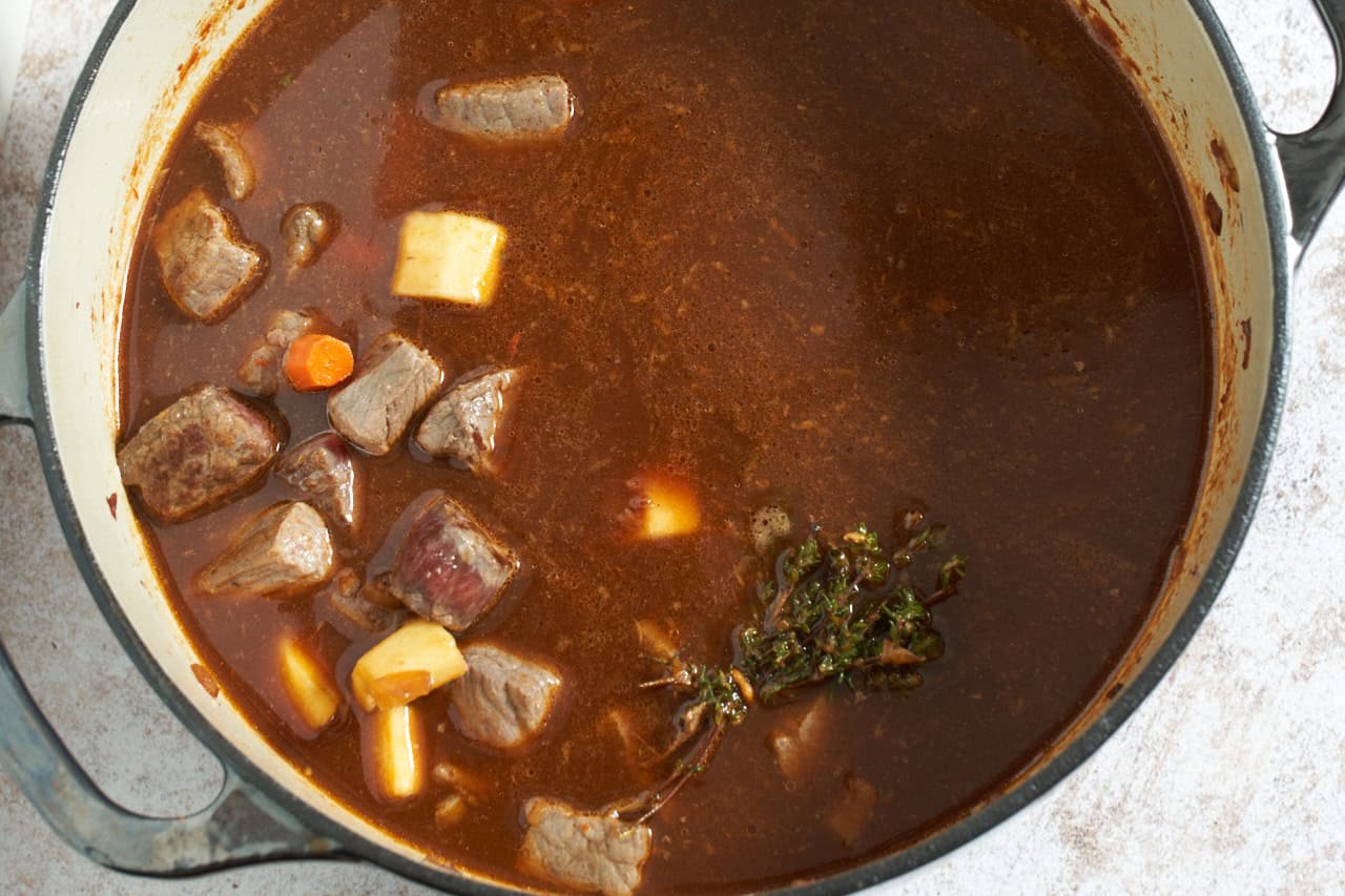 Guiness stew in a dutch oven ready to be simmered.