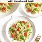 Three plates of summer corn pasta salad topped with cherry tomatoes and fresh basil, a gold fork is on the right, a red and white striped towel is on the left.