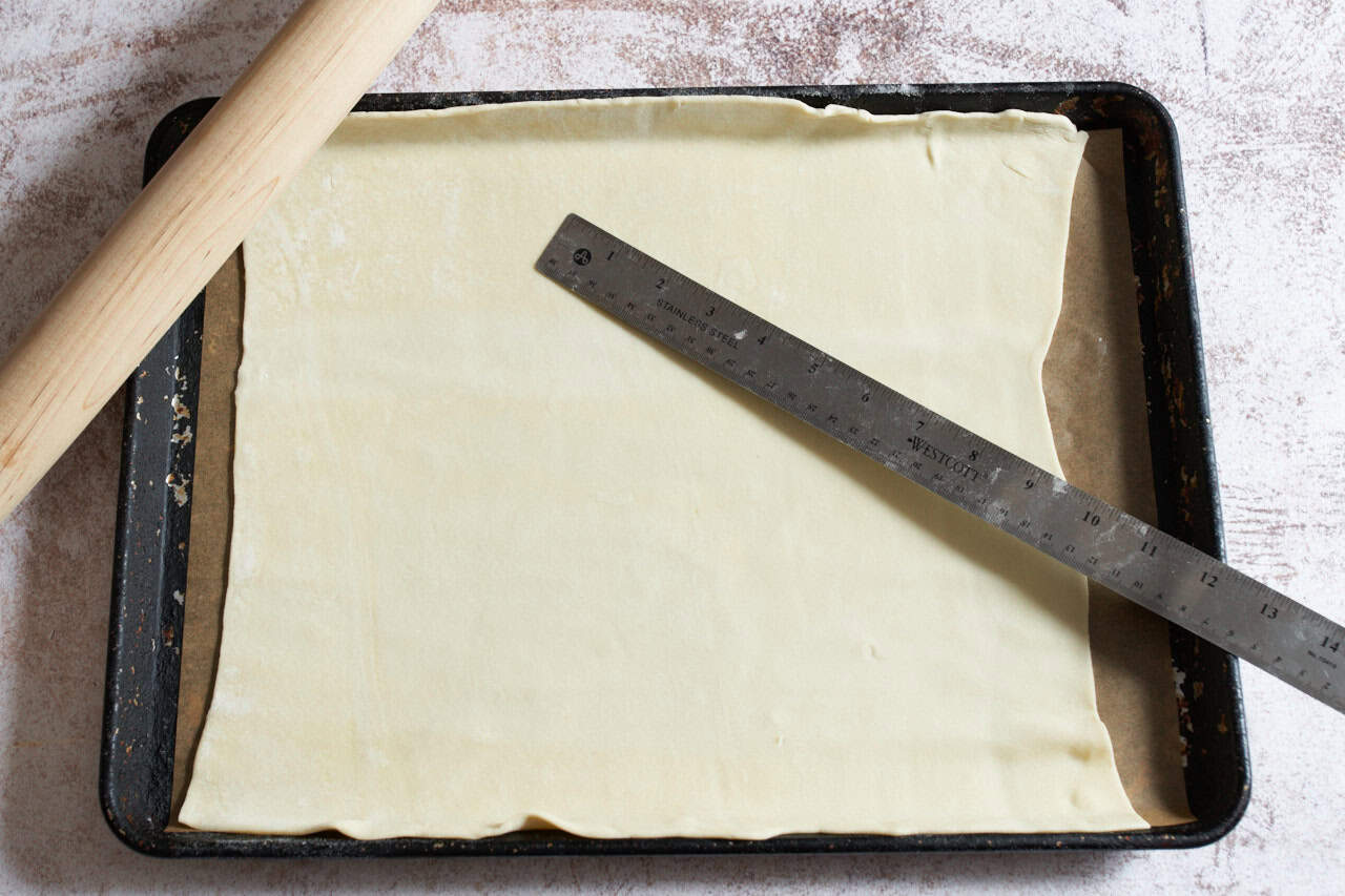 Puff pastry rolled into a square on a parchment lined baking sheet.