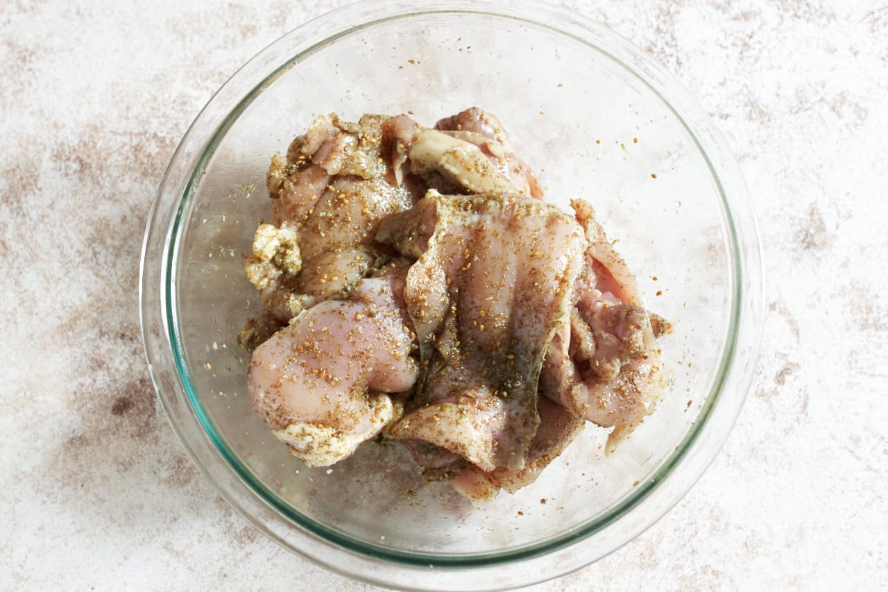 Chicken thighs marinating in za'atar spice.