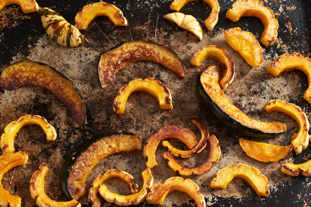 Roasted acorn and butternut squash on a sheet pan.